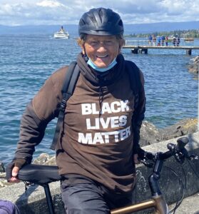 Jerry in helmet on bike by Lake Geneva wearing Black Lives Matter tee-shirt